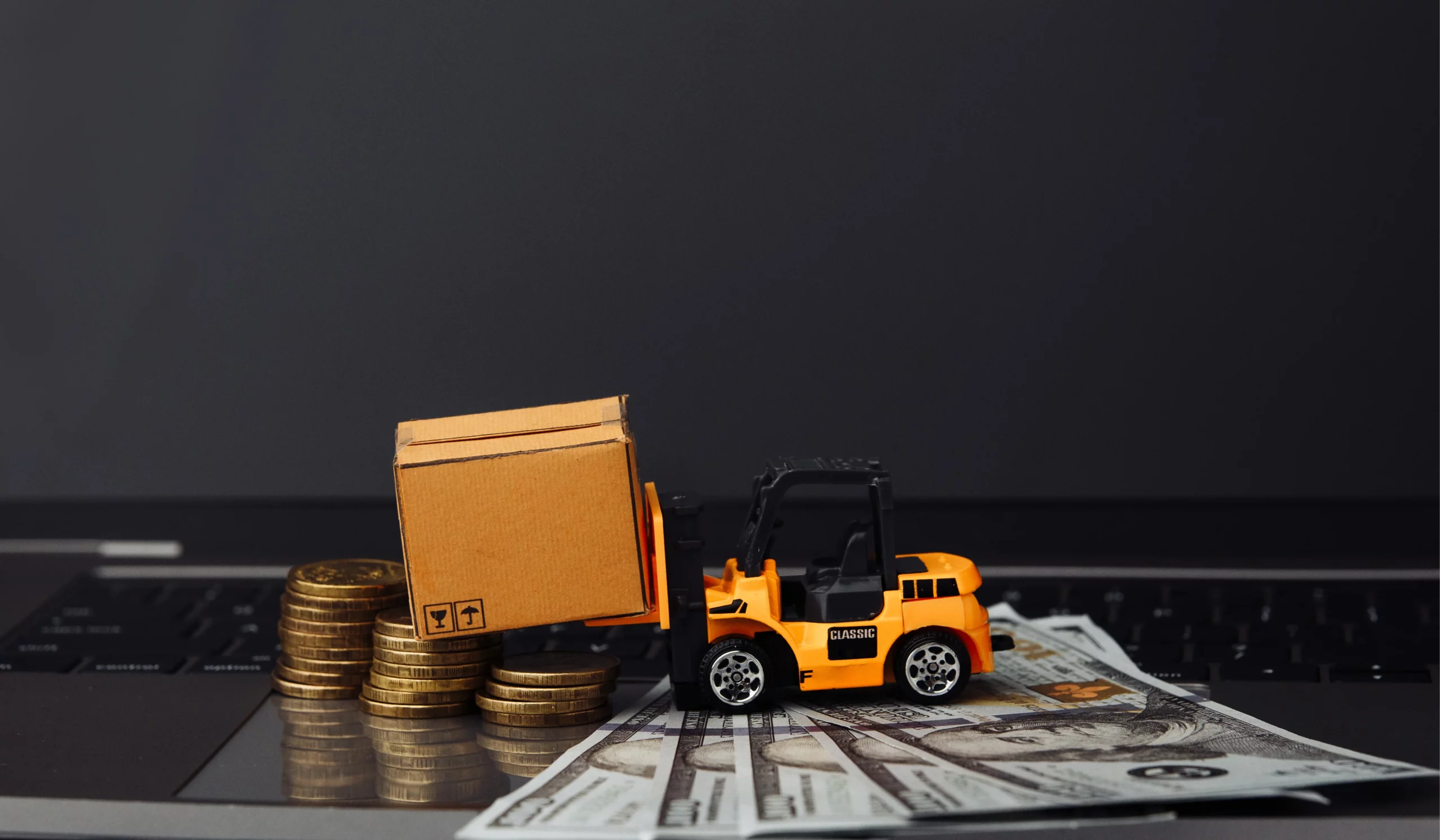 mini model of a truck lifting cardbox and dollars